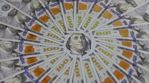 A Closeup of Many Hundreddollar Bills Lie in an Even Circle and Slowly Rotate
