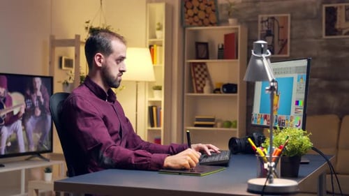 Young Adult Using Graphics Tablet at Desk