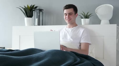Man in Bed Video Calling with Laptop