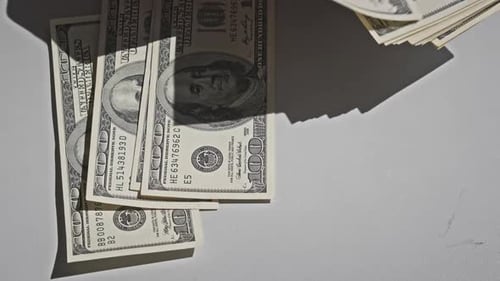 Männliche Hände zählen alte Hundert-Dollar-Banknoten auf einem weißen Tisch