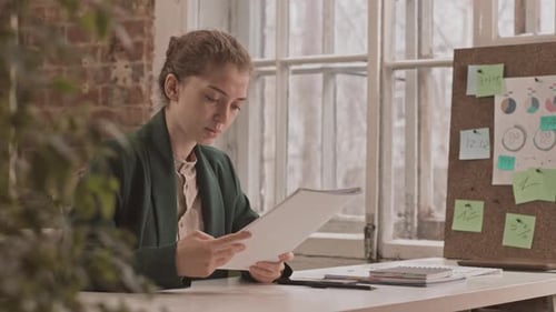 Serious Businesswoman Working with Documents in Office