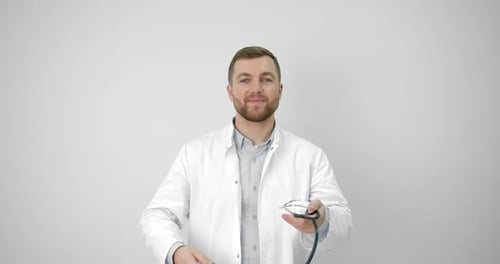 Friendly Doctor Puts on Stethoscope in Studio