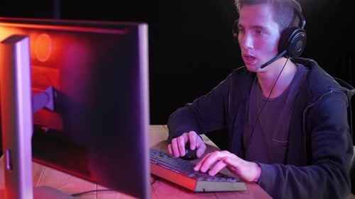 Young Adult Using Computer in Dimly Lit Room