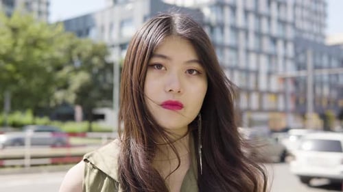 Young Asian Woman Looks Seriously Camera Street Urban Area Closeup