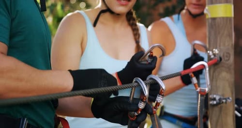 Adults Prepare for Zip Line Adventure Course