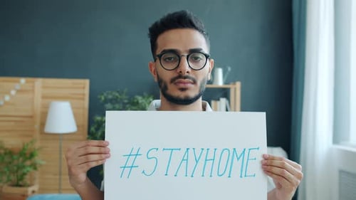 Young Adult Holds Stay Home Sign