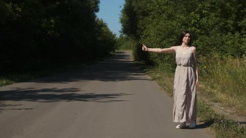 Young Woman Hitchhiking on a Country Road
