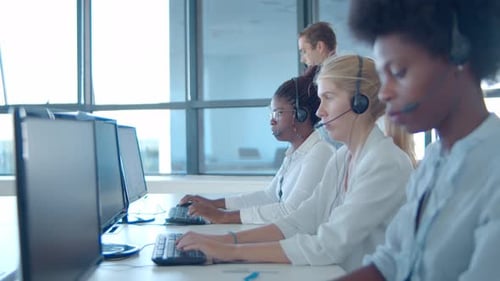 Male Call Center Manager Standing By Operators Headsets