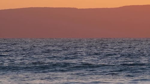 Natural Dramatic Sunrise Seascape with Mountains Sunset Sun Shining Through Waves Ocean and Sea Slow
