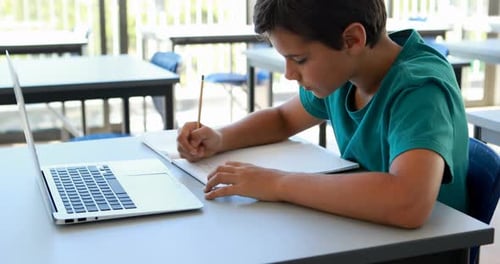 Focused Student Studying with Laptop in Classroom