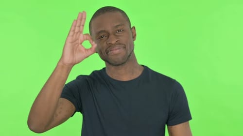 Ok Sign By Young African Man on Green Background