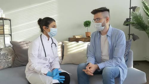 Doctor Visits Patient Wearing a Mask on Sofa