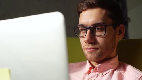 Young Adult Working at Computer in Office