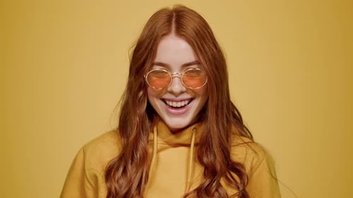 Smiling Woman With Auburn Hair and Round Glasses