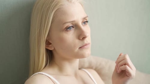 Young Woman Taking Pill with Water Indoors