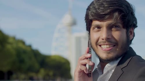 Smiling Young Adult Talking on Phone in the City