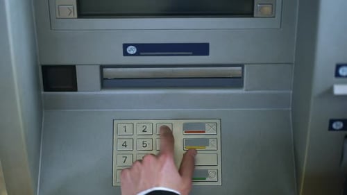 Männliche Hand, die den PIN-Code am Geldautomaten eingibt und Euro-Geld abhebt, Ansicht von oben