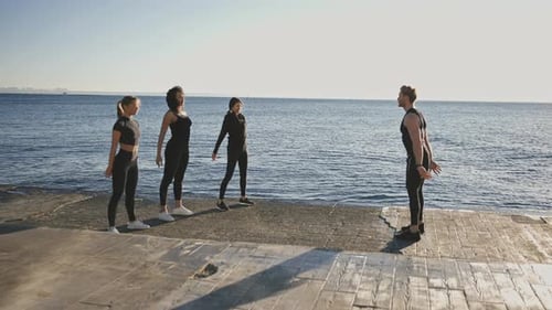 People Doing Squats at the Ocean