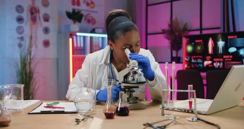 Female Scientist Using Microscope in Laboratory Setting