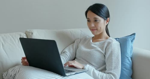 Woman Uses Laptop While Sitting on Couch