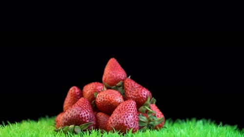 Juicy strawberries, placed on black background under the fall of smoke