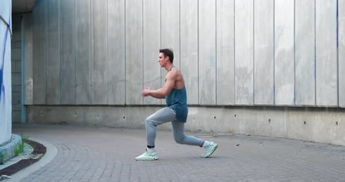 Man Performing Alternating Lunges in Urban Setting