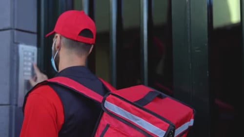Rider man livrant un repas aux clients à domicile tout en portant un masque facial