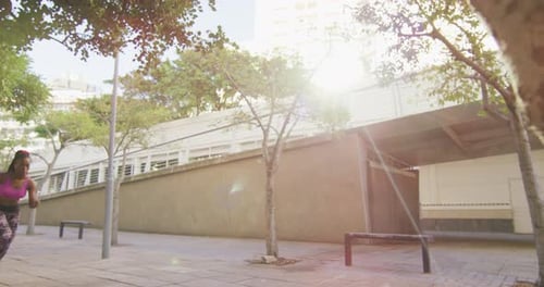 African american woman exercising outdoors wearing wireless earphones running in the city
