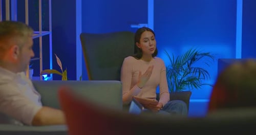 De jeunes blogueurs s'assoient dans des fauteuils dans une pièce et discutent