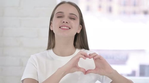 Smiling Woman Makes Heart Shape With Her Hands