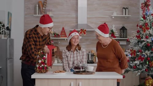 Family Celebrates Christmas with Gifts in Kitchen
