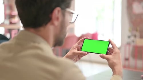 Man Holding Smartphone With Green Screen Display