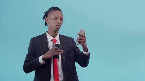 Young Adult Talking on Phone and Drinking Coffee