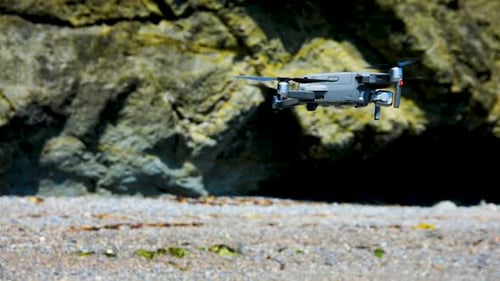 Drone Flying Near Rocky Cliffs On A Beach