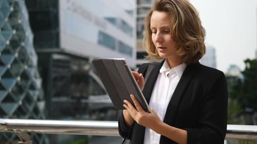 Businesswoman Uses Tablet in Urban Setting