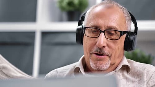 Senior Man with Headphones Talking Indoors