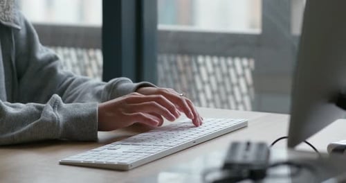 Woman type on desktop computer