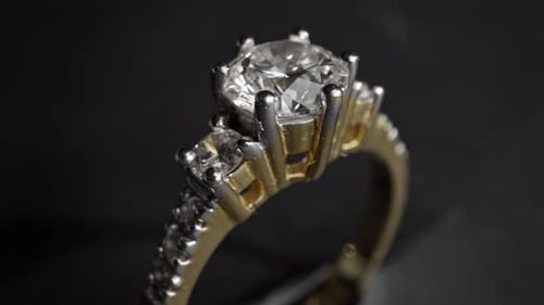 Extrem detaillierte Nahaufnahme des Diamantrings beim Drehen auf dunklem Hintergrund