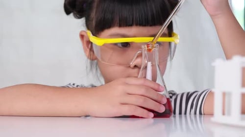 Young Child Conducts Science Experiment with Dropper