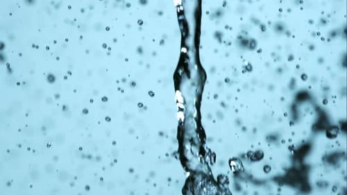 Pouring Water Droplets on Bright Blue Background