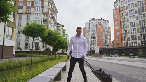 Man with Bag on Bench in Modern Urban Setting