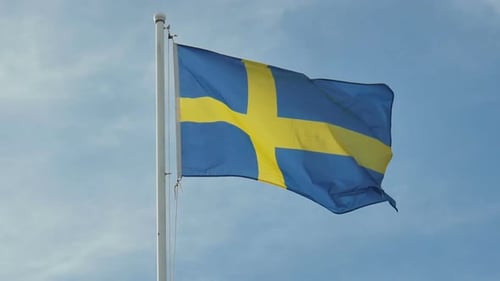 Swedish Flag Waving Against Blue Sky