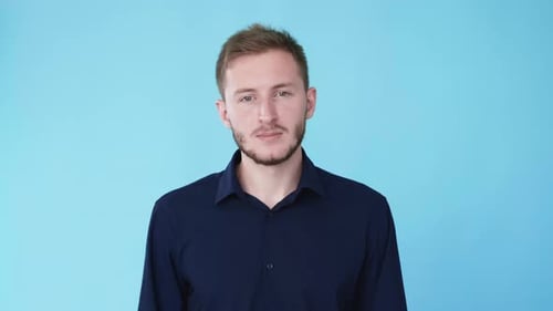 Young Man Talking on Cellphone on Blue Background