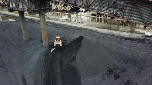 Kohleumschlag im Werk. Crawler Bulldozer funktioniert. Luftaufnahme.