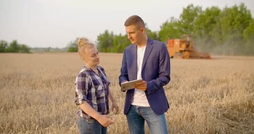 Farmers Discussing Harvest with Tablet in Wheat Field