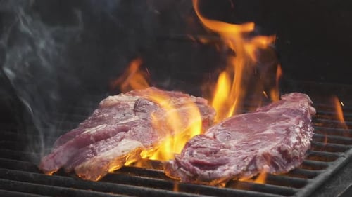 Steaks Cooking on Flaming Hot Grill
