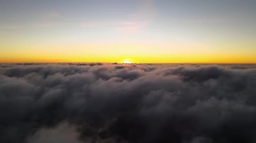 Aerial View From Above at High Altitude of Dense Puffy Cumulus Clouds Flying in Evening