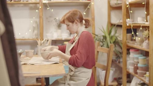 Young Caucasian Woman Forming Clay Bowl in Pottery Studio