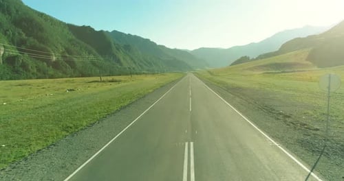 Voo aéreo de baixa altitude sobre Mountain Road e Meadow na manhã ensolarada de verão.