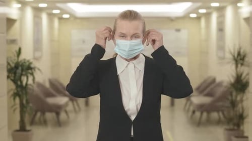 Professional Puts on Protective Surgical Mask